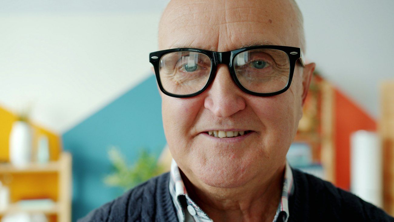 Ein lächelnder älterer Mann mit Brille