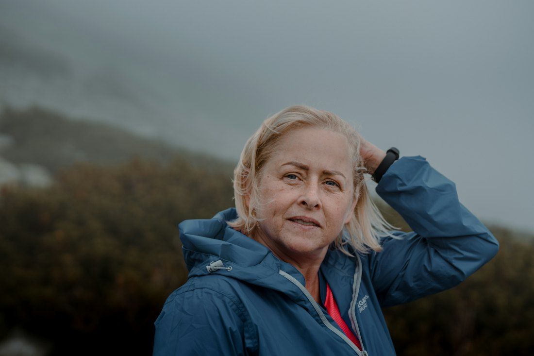 Een vrouw met blond haar lacht buiten